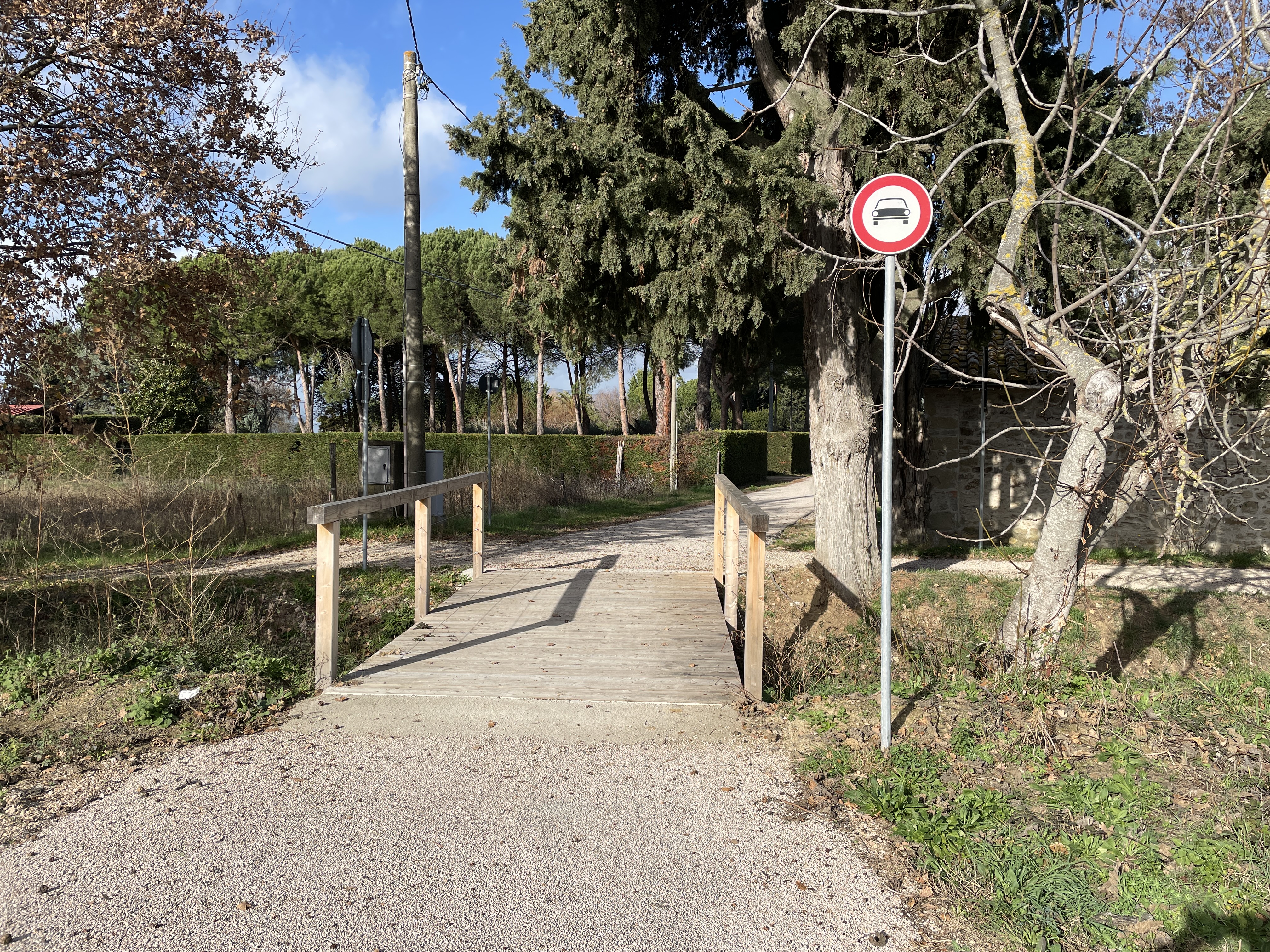 Kleine Holzbrücke, ohne Stockschlag und taktile Markierungen. Ein Schild verbietet den Zugang mit Kraftfahrzeugen.